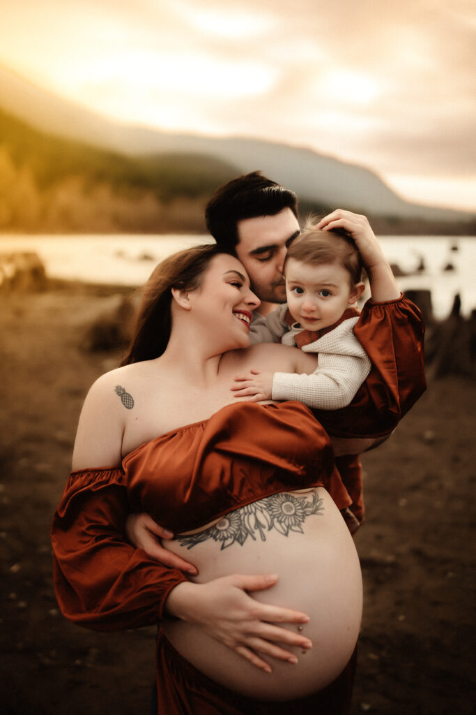 A pregnant mom and family loving on their baby while being photographed by a washington state maternity photographer
