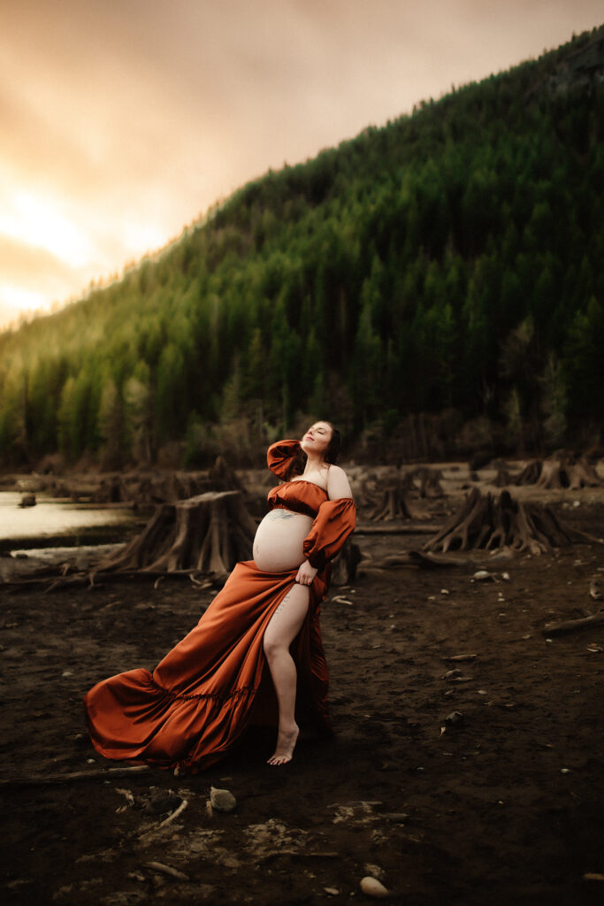 a mom embracing the wind and sun on her face while being photographed by a washington state maternity photographer