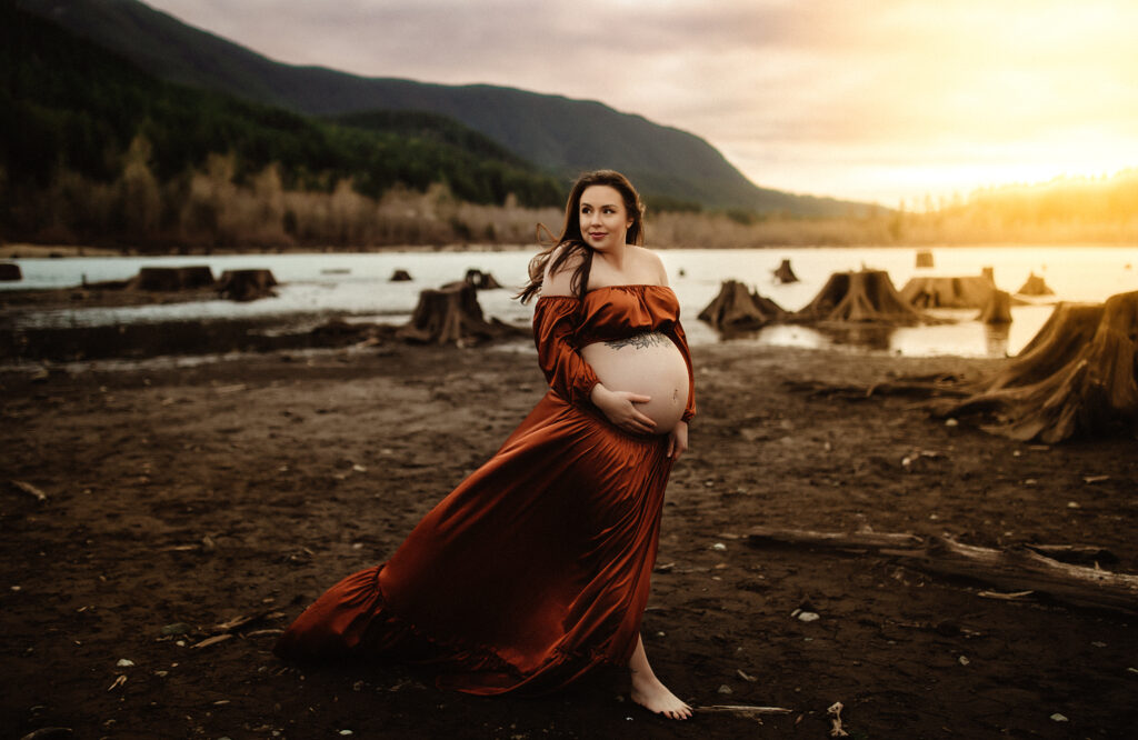 A pregnant mom walking at rattlesnake lake being photographed by a washington state maternity photographer